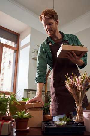 Florist gathering boxes with plants