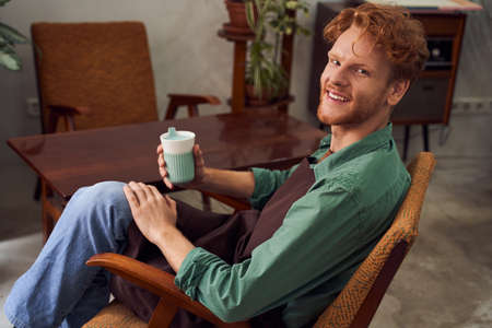 Florist sitting on chair drinking coffee