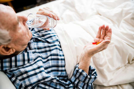 Old man drinking glass of waterの写真素材