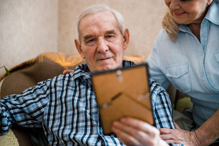 Man holding family portrait in photo frame