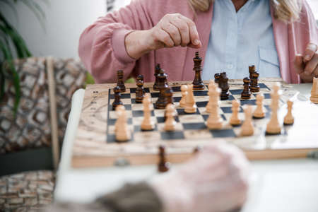 Retired couple playing chess on wooden tableの写真素材