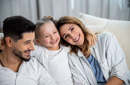 Parents and their cute little daughter hugging