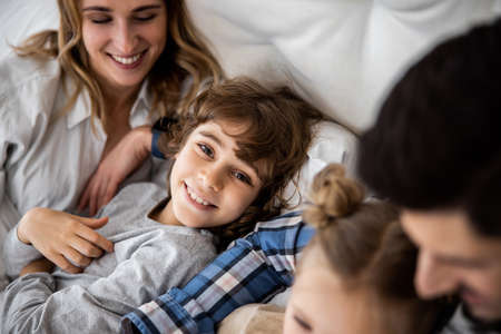 Happy family with two kids under blanketの写真素材
