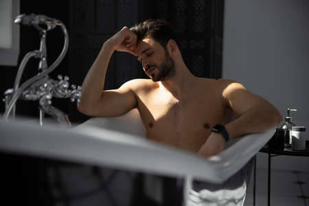 Relaxing handsome man with beard in bathtubの写真素材