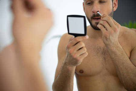 Close up shot of man pinching hairs in the noseの写真素材