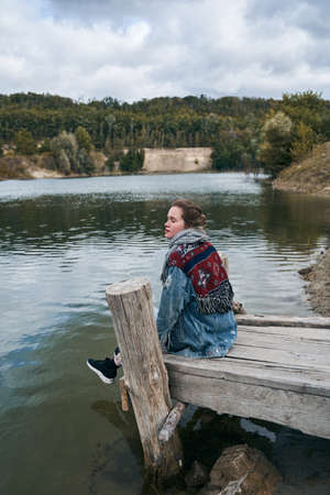 Woman sitting at the wooden bridge