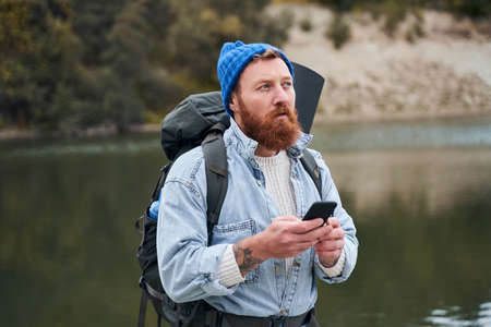 Man with backpack pondering where to goの写真素材