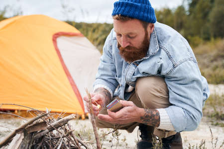 Man making a fire with matchesの写真素材