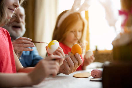 Beautiful colorful eggs in hands of family members stock photoの写真素材