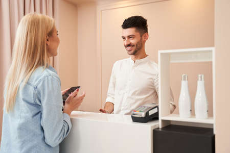 Female client standing at the receptionの写真素材