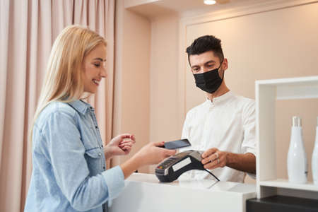 Hairdresser with medical mask and customer
