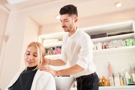 Hairdresser preparing client to the washing hairの写真素材