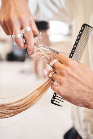 Hairdresser cutting the hair of a blonde womanの写真素材