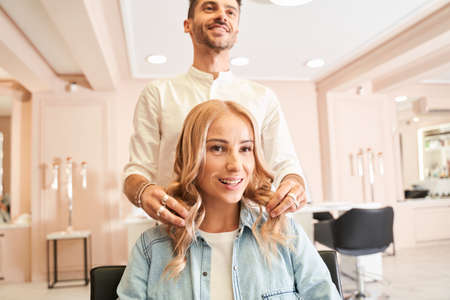 Hairdresser styling the hair of a customerの写真素材
