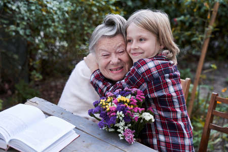 Child cuddling his grey haired granny
