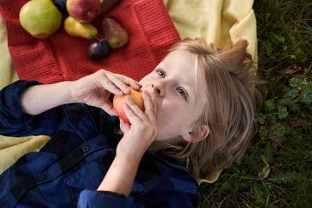 Boy looking dreamily at the skyの写真素材