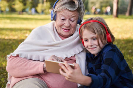 Boy listening music with his grannyの写真素材