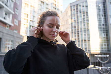 Woman inserts earphones