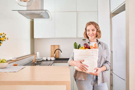 Housewife hugging a large bag of groceriesの写真素材