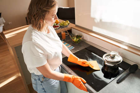 Woman scrubbing and cleaning the stoveの写真素材
