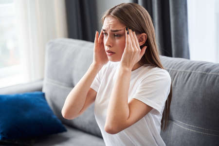 Woman holding her hands to the head