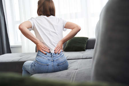 Woman touching back while feeling backache