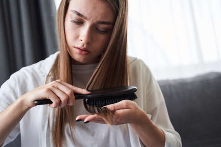 Woman looking at damaged hair tipsの写真素材