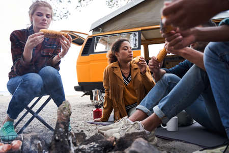 Friends enjoying eating delicious cornの写真素材