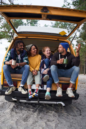 People sitting at the car while travelling togetherの写真素材
