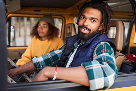 Man driving a car and looking to the window