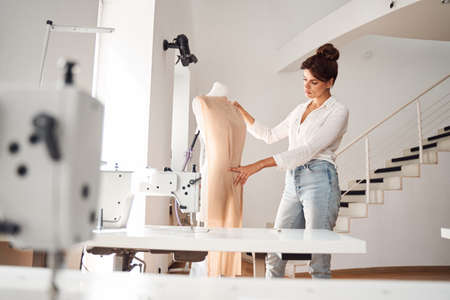 Dressmaker attaching fabric to mannequinの写真素材