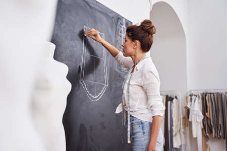 Woman drawing on a chalkboard patterns