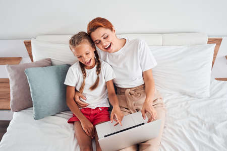 Mother and daughter looking at laptop screen