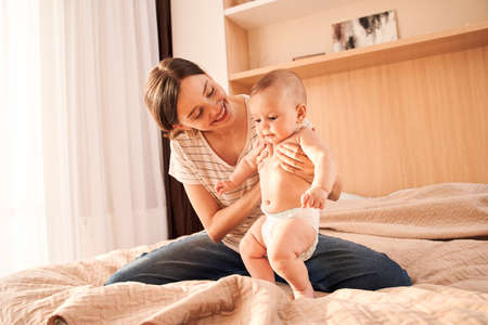 Mother helping to son doing his first steps