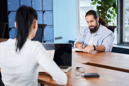 Concentrated man is sitting at deskの写真素材