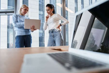 Coworkers using a laptop togetherの写真素材