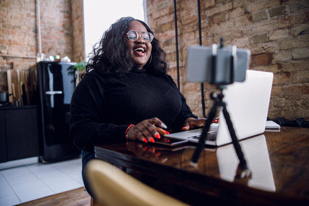 Laughing blogger at home with gadgets stock photoの写真素材