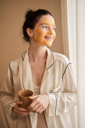 Woman standing at the room and drinking coffeeの写真素材