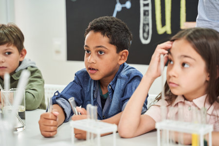 Smart cute pupils listening a teacher about chemical experiments