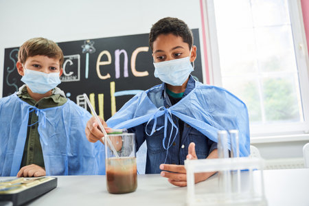 Two curious cute boys in protective masks and gowns