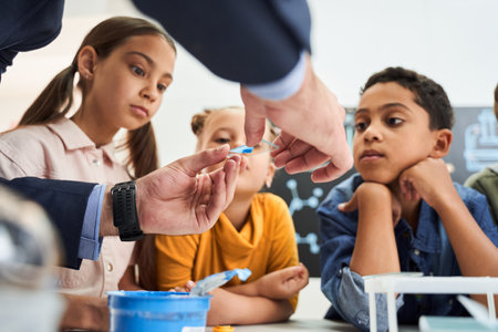 Cropped view of adult teacher showing test glass to his pupils