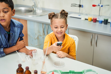 Cute smiling caucasian girl holding chemistry gadget in her handsの写真素材