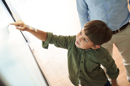 Inquisitive brunette caucasian boy showing at something at whiteboardの写真素材