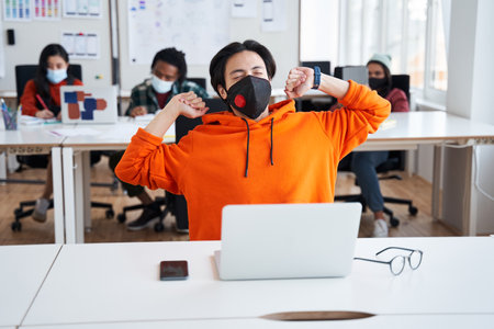 Student man stretch while working with laptop computer at classroomの写真素材