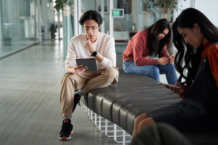 Group of serious friend or students while sitting at the benchの写真素材