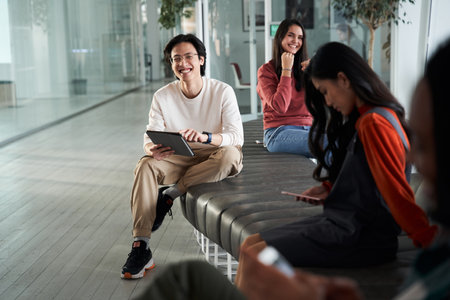 Group of happy friend or students while sitting at the benchの写真素材