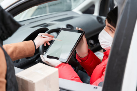 Customer girl sign at the tablet while taking boxの写真素材