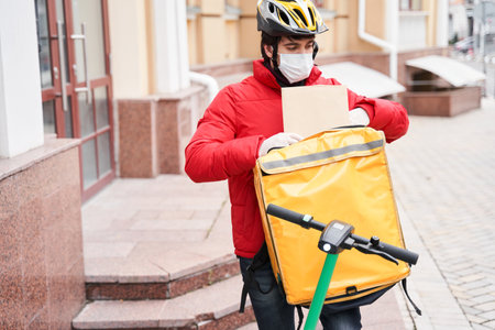 Delivery man preparing to giving package to customerの写真素材