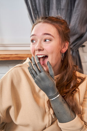 Woman with artificial limb laughing and covers her mouth with her handの写真素材