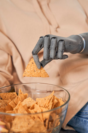 Woman with implant arm eating pepper nachos chips
